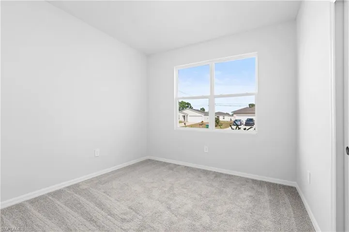 Unfurnished room with light carpet and baseboards