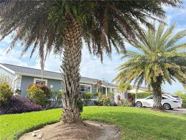 View of front of home with a front lawn and stucco siding