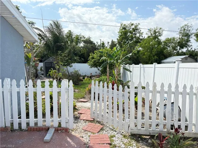 View of yard with a fenced backyard, an outdoor structure, and a storage unit