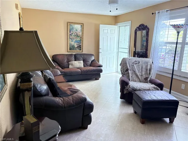 Living area with light tile patterned floors and a textured ceiling