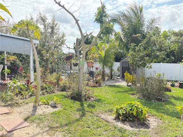 View of yard featuring a shed, fence, and an outbuilding