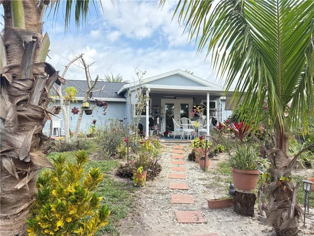 View of yard featuring a porch and french doors