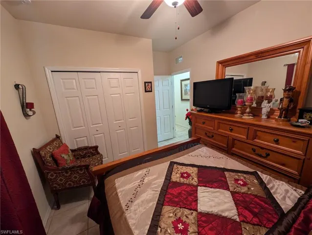 Tiled bedroom with a closet and ceiling fan