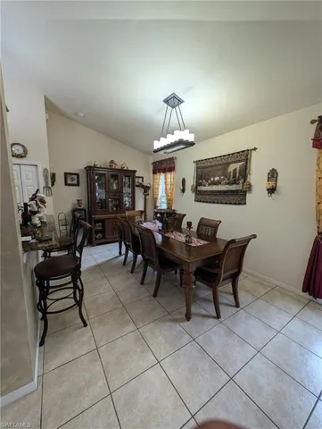 Dining space with vaulted ceiling and light tile patterned floors