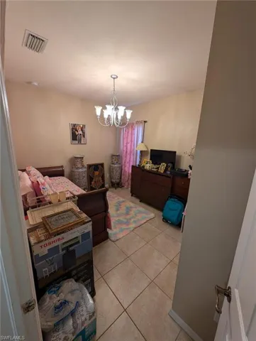 Dining area with light tile patterned floors and a chandelier