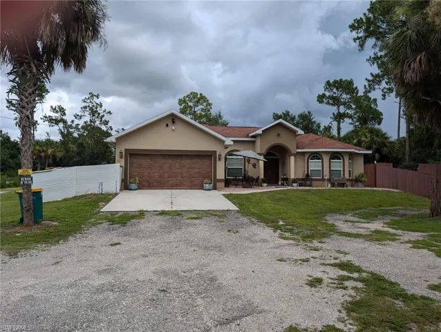 View of front facade featuring concrete driveway, stucco siding, and an attached garage