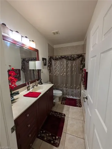Bathroom featuring tile patterned flooring, vanity, and curtained shower