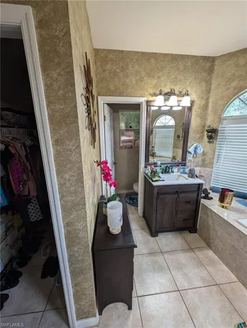 Bathroom with tile patterned flooring, vanity, and a spacious closet