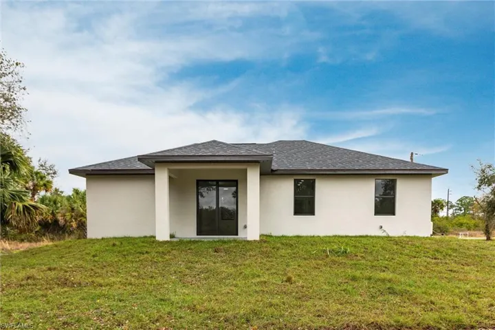 Rear view of property with a yard