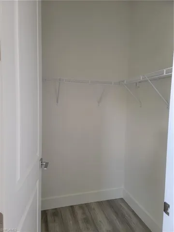 Walk in closet featuring dark wood-type flooring