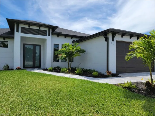 View of front of home with a front yard and a garage