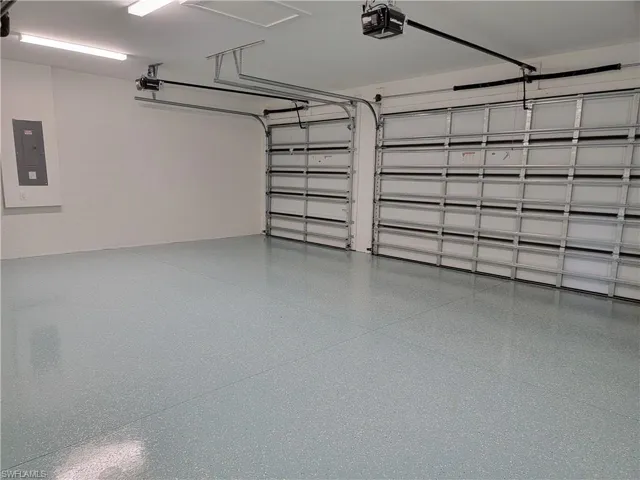 Garage featuring a garage door opener and electric panel
