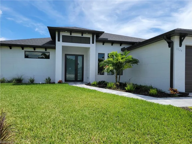 View of exterior entry featuring a yard