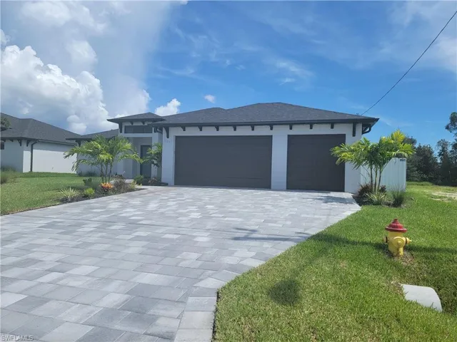 View of front of property with a front lawn and a garage
