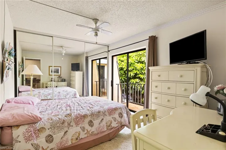 Guest bedroom #1 with slider leading to balcony that overlooks patio.