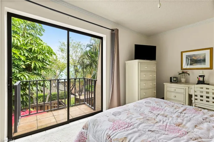 Guest bedroom #1 with slider and balcony that overlooks patio.