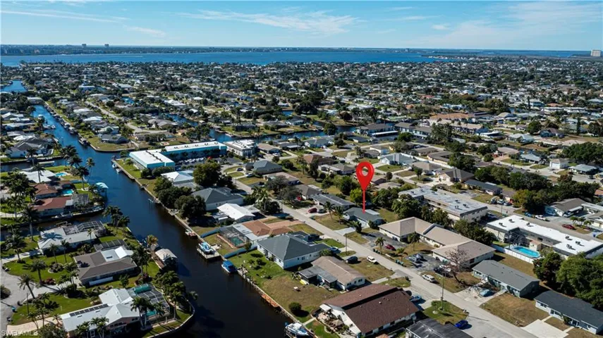 Aerial view of property's location with a large body of water and nearby suburban area