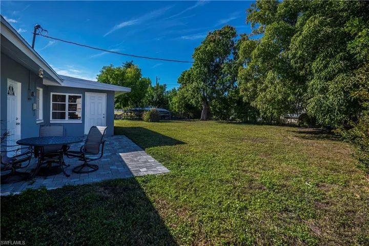 View of grassy yard featuring a patio