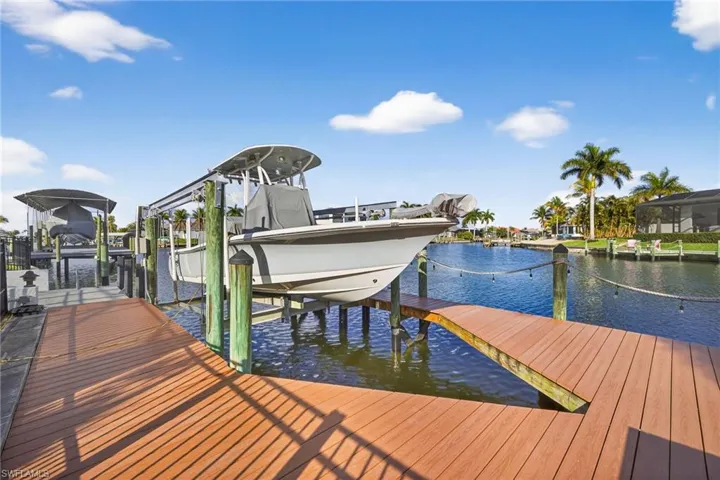 Dock area featuring boat lift and newly wrapped pilings