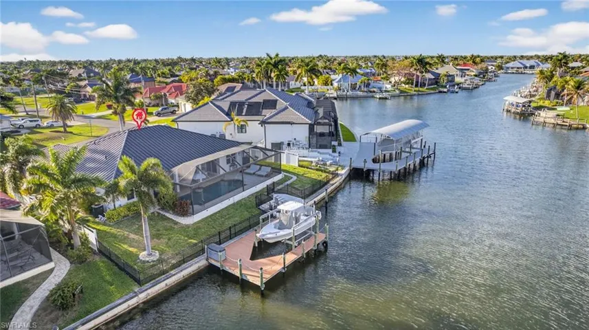 Dock area featuring a lanai, a large water view, boat lift, & residential view