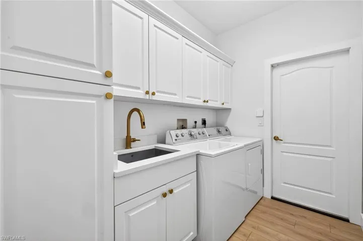 Laundry area with cabinet space, Pantry, LVP flooring, and washer & dryer, sink