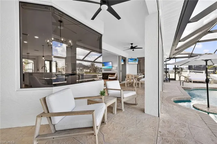 View of patio featuring a covered area, ceiling fans, an outdoor heated pool w/new pool pump (2026), and an outdoor living / dining area