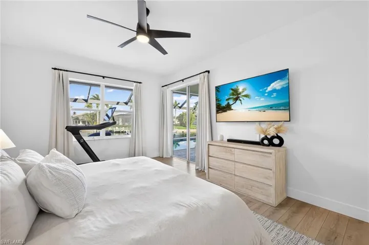 Primary bedroom featuring LVP, ceiling fan, and access to pool patio