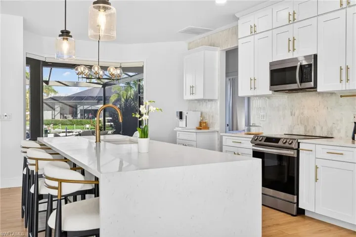 Waterfall quartz countertop, brushed gold-tone faucet & hardware