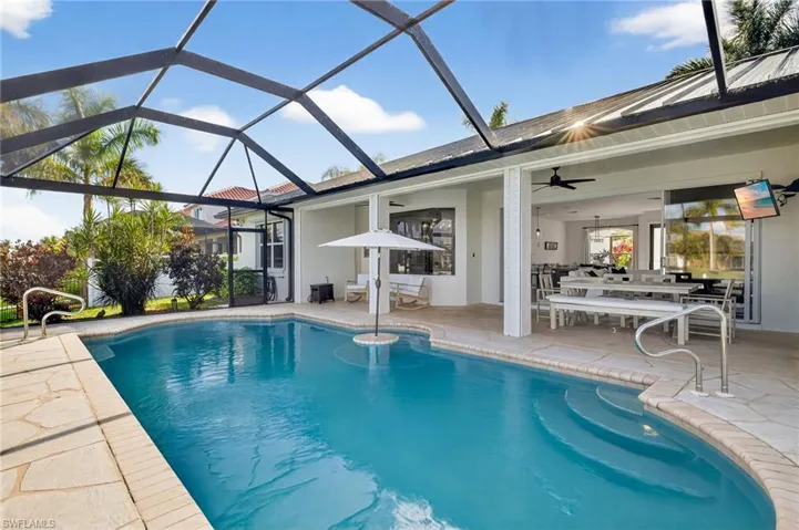 Outdoor heated pool featuring outdoor dining space, new screened enclosure, a patio
