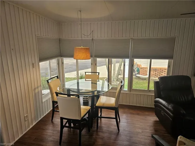 Dining area featuring dark hardwood / wood-style floors and wooden walls