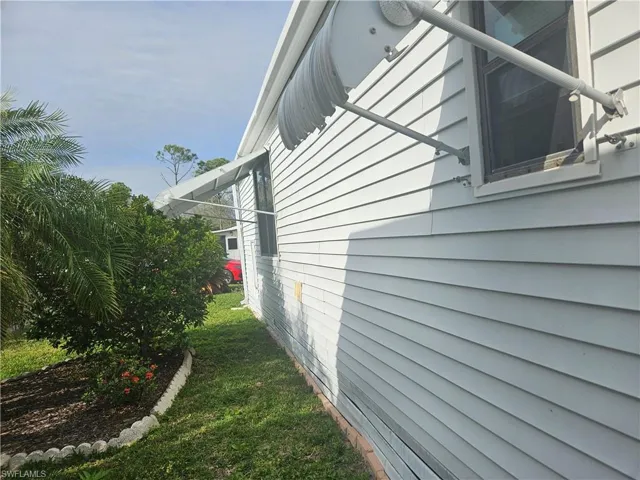 View of side of home featuring a yard