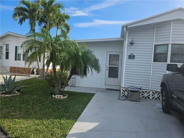 View of exterior entry featuring a patio and a lawn
