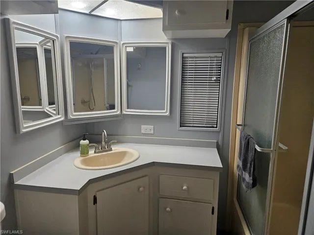 Bathroom with vanity and a shower with door