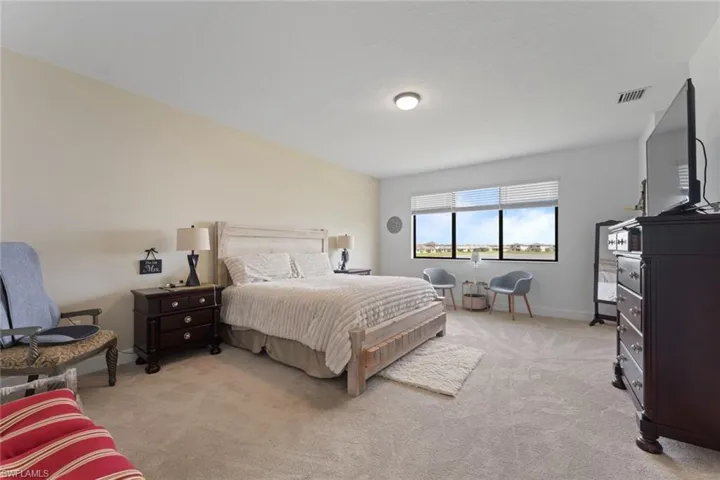 Bedroom with light carpet, baseboards, and visible vents