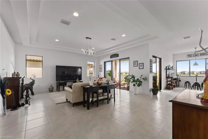 Living area featuring plenty of natural light, visible vents, a raised ceiling, and light tile patterned flooring