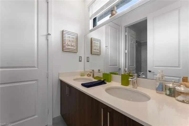 Full bathroom with double vanity, walk in shower, and a sink