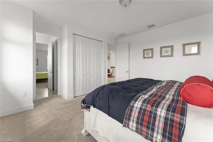Bedroom with carpet floors, baseboards, visible vents, and a closet