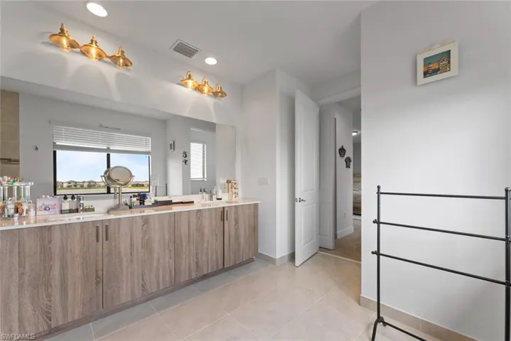 Bathroom with recessed lighting, double vanity, visible vents, and tile patterned floors