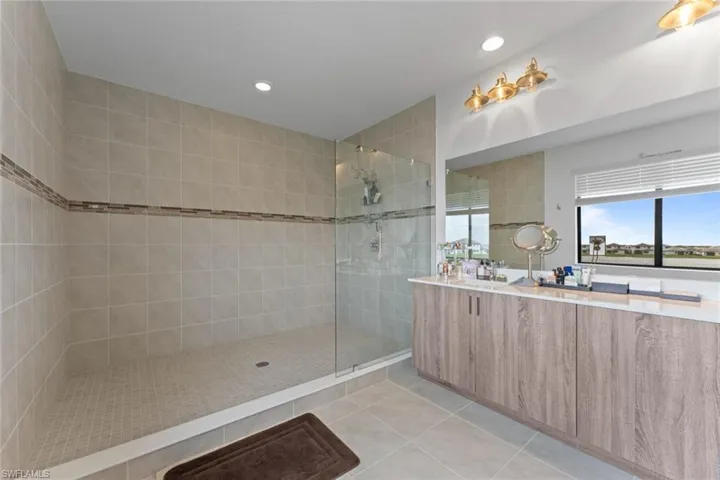 Full bath featuring recessed lighting, vanity, walk in shower, and tile patterned floors