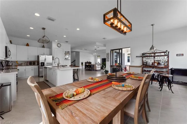 Dining space featuring light tile patterned floors, visible vents, and recessed lighting