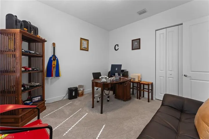 Carpeted office featuring visible vents and baseboards
