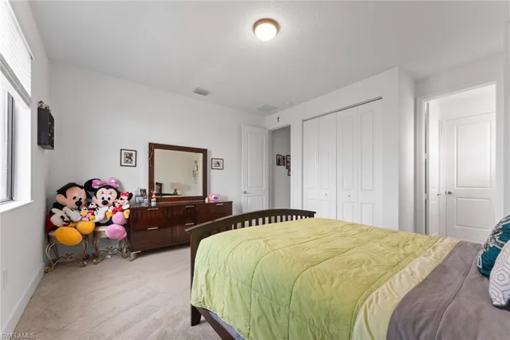 Bedroom featuring baseboards, visible vents, a closet, and light colored carpet