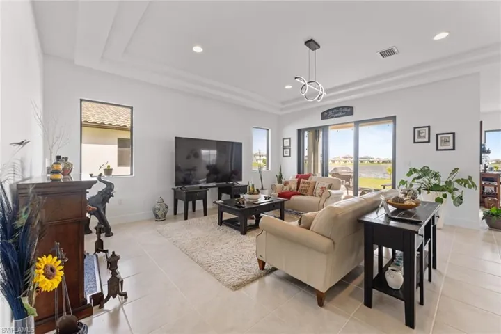 Living room featuring light tile patterned floors, recessed lighting, visible vents, and baseboards