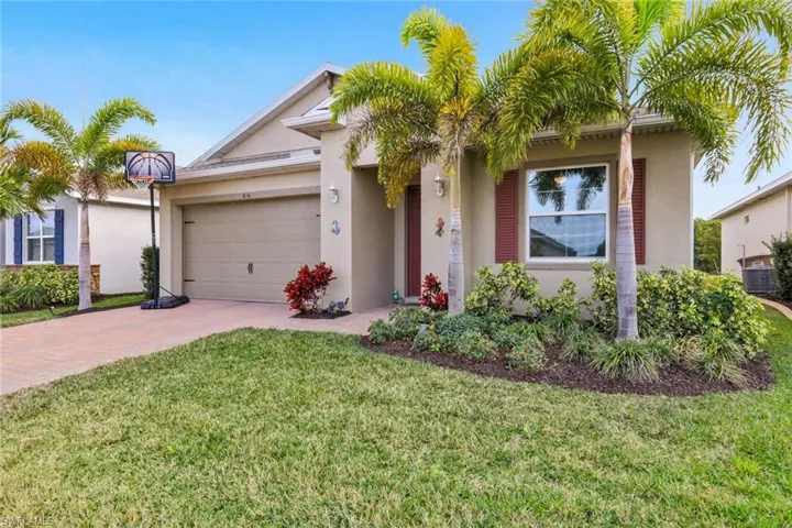 View of front of property with stucco siding, a front lawn, decorative driveway, and an attached garage