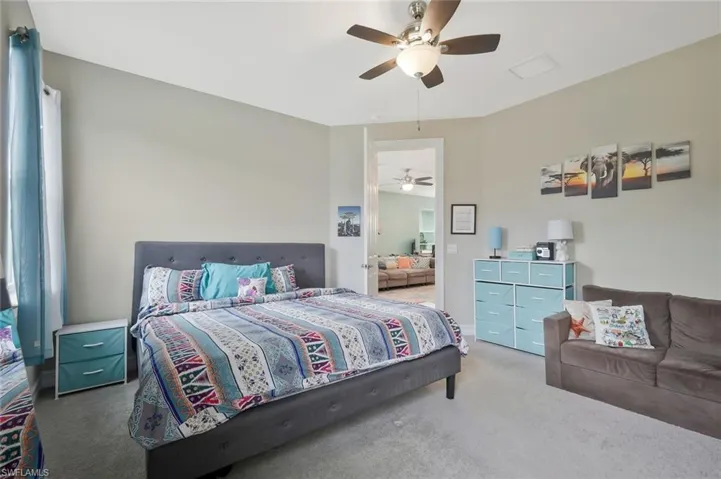 Carpeted bedroom with a ceiling fan
