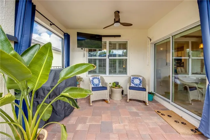 Covered patio featuring paver flooring, a ceiling fan, and sliding glass doors