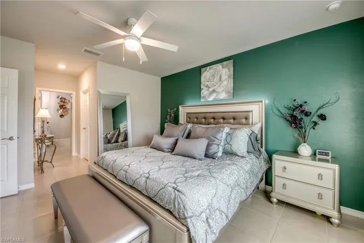 Recessed lighting, ceiling fan, tile flooring, accent wall, and paneled doors
