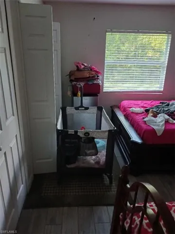 Bedroom with dark wood-style flooring