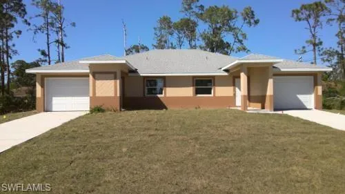 Ranch-style home featuring a garage, concrete driveway, a front lawn, and stucco siding