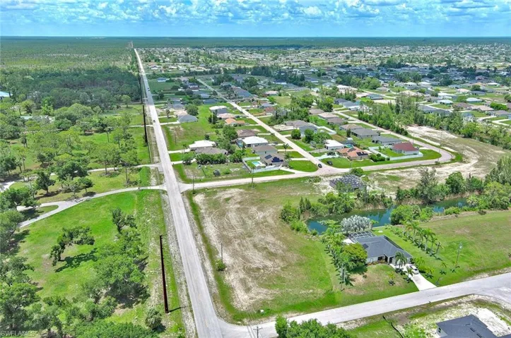 Aerial view of property's location featuring a nearby body of water and nearby suburban area
